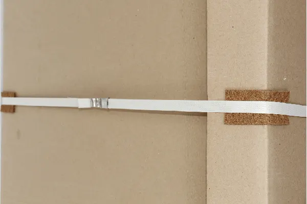 Coir edge protectors on a strapped carton